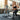 Gray weightlifting barbell with Olympic plates on rack, steel gym workout equipment